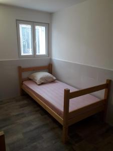 een kleine slaapkamer met een bed en een raam bij 143 VH in Le Blanc-Mesnil