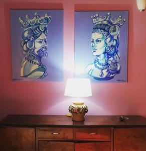 two paintings of two women with crowns on a wall at Donna Lucia in Giardini Naxos