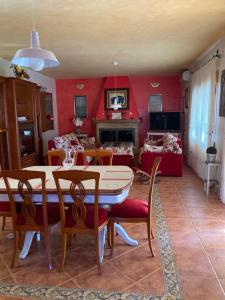 une salle à manger avec des murs rouges, une table et des chaises dans l'établissement Casa El Sol, à Mota del Cuervo