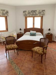 - une chambre avec un lit et deux chaises dans l'établissement Casa El Sol, à Mota del Cuervo