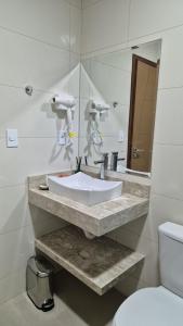 a bathroom with a sink and a mirror at Pousada Recanto Família in Paraty