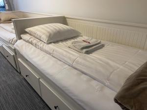 Una cama con sábanas blancas y una toalla. en Vid Gekås Ullared Boende B&B, en Ullared