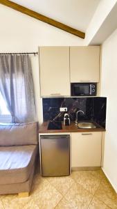 a small kitchen with a sink and a microwave at Oasis Apartment Ammoudia in Ammoudia