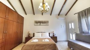 a bedroom with a bed and a chandelier at Oasis Apartment Ammoudia in Ammoudia
