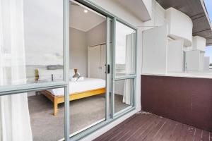 um quarto com portas de vidro deslizantes e uma cama em Holiday Home Flat Bush em Auckland