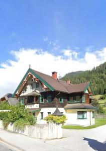 una grande casa con tetto marrone e verde di Fewo Mima a Oberweissburg