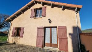 een klein huis met rode deuren en ramen bij Les Mésanges - Jardin - Nature in Agnat