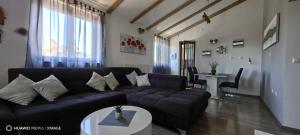 sala de estar con sofá negro y mesa en Apartment Brioni Sea,Garden,Poll view 2 plus 2 80m2 tiki bar, en Peroj