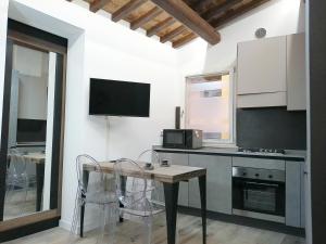 cocina con mesa y sillas y TV en Nel Cuore di Perugia, en Perugia