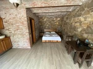 a bedroom with a bed and a brick wall at Deniz butik otel in Sirince