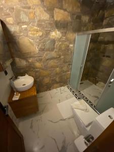 La salle de bains est pourvue d'un lavabo et d'une douche en verre. dans l'établissement Deniz butik otel, à Sirince