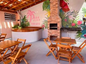 a patio with tables and chairs and a fireplace at Pousada Pura Vida Bertioga in Bertioga