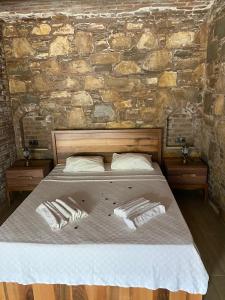 uma cama num quarto com uma parede de pedra em Deniz butik otel em Sirince