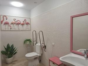 bagno con servizi igienici, lavandino e specchio di La casa de las flores a Toro