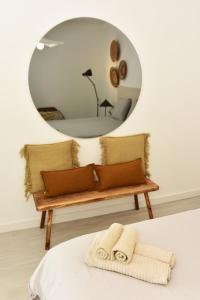 a mirror above a bench with pillows in front at Casa Lucia in Villaverde