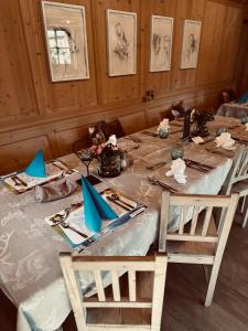 a long table with two chairs and blue napkins on it at Alpen Hotel Post in Au im Bregenzerwald +73 photos