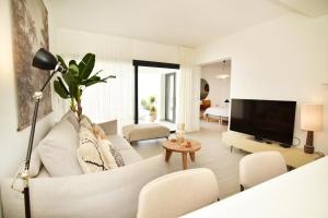 a living room with a white couch and a tv at Casa Lucia in Villaverde