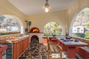 an outdoor kitchen with a table and a fireplace at RENT HOUSE BEACH MIRTOFITO 8 km FROM PERAMOS in Elaiokhórion