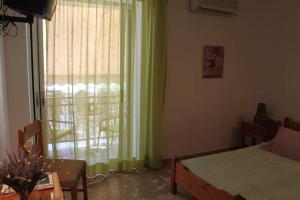 a bedroom with a bed and a window with a patio at Cozy double apartment near the sea in Tolo