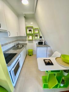 eine kleine Küche mit einer Spüle und einer Theke in der Unterkunft Ático Deluxe San Ciprian in San Cibrao
