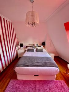 ein Schlafzimmer mit einem großen Bett mit einem rosa Teppich in der Unterkunft Ático Deluxe San Ciprian in San Cibrao