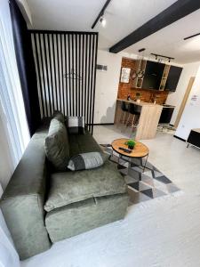 een woonkamer met een bank en een tafel bij Apartman Ceca Pale in Pale