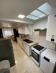 una cucina con mobili bianchi e un forno a piano cottura di Maison de pêcheur typique a Étaples Altre 5 foto