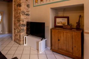 a living room with a flat screen tv on top of a wooden cabinet at La Nicchia in San Gimignano