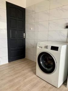 lavadora en una habitación con puerta negra en Luxe akpakpa, en Agbato
