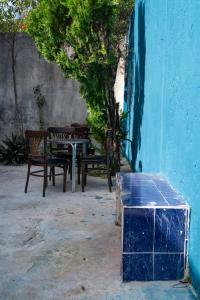 une table et des bancs à côté d'un mur bleu dans l'établissement Casa Playa Hermosa, à Cancún