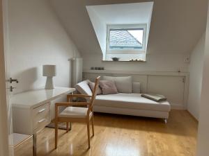 a room with a couch and a desk and a window at Alta Villa - Ferienwohnung in Eltville