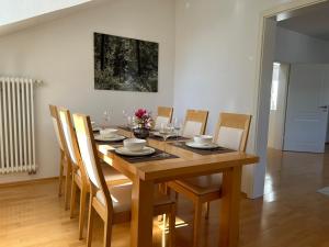 a dining room with a wooden table and chairs at Alta Villa - Ferienwohnung in Eltville +9 photos