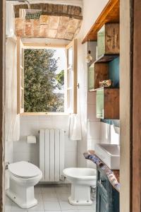 a bathroom with a toilet and a sink and a window at La Nicchia in San Gimignano