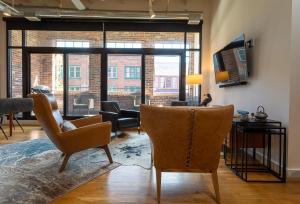 a living room with two chairs and a television at The Press Loft in Asheville