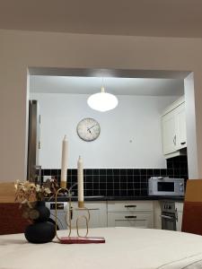 a kitchen with a clock on the wall and a table at Saint Saviour's Apt Waterford in Waterford