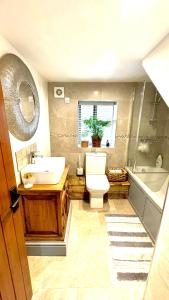 uma casa de banho com um lavatório, um WC e uma banheira em Swallow Barn em Penrith