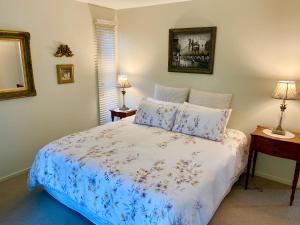 a bedroom with a bed and two lamps and a mirror at "La Petite Grange" Maleny in Maleny