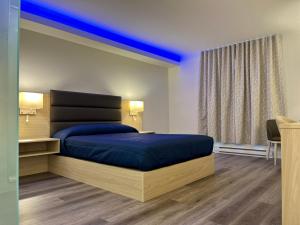 una camera con letto e visiera blu di Motel Mascouche a Mascouche