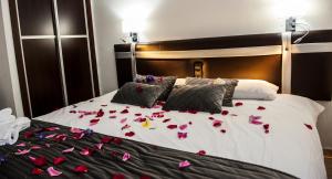 a bed with pink flower petals on it at HOSTAL LAS PALOMAS in Lucena