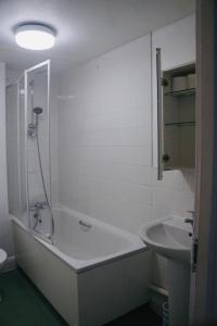 biała łazienka z wanną i umywalką w obiekcie Bustling Western Apartment w Londynie