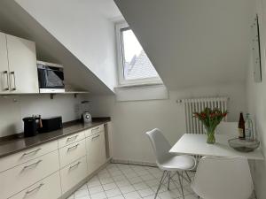 une cuisine blanche avec une table et une fenêtre dans l'établissement Alta Villa - Ferienwohnung, à Eltville