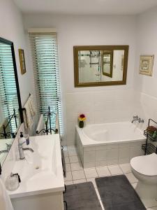 a bathroom with a tub and a sink and a toilet at "La Petite Grange" Maleny in Maleny