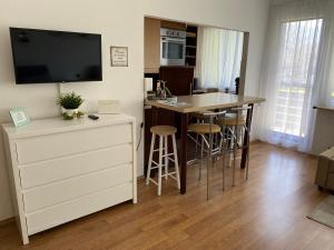 a living room with a kitchen with a table and a counter at Rosebeach Appartement am Ossiachersee in Bodensdorf