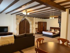 a living room with a bed and a couch and a table at Posada Spa San Marcos in Santillana del Mar