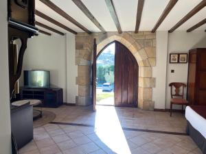 een toegang tot een kamer met een deur en een tv bij Posada Spa San Marcos in Santillana del Mar