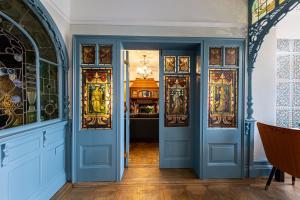 a hallway with blue doors and stained glass at Escape Boutique B&B in Llandudno