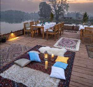 una mesa con almohadas y velas en una terraza en Naaz Kashmir Houseboat en Srinagar