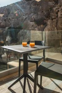 Dois copos de sumo de laranja sentados numa mesa. em Blu Waters Boutique Hotel em Xlendi