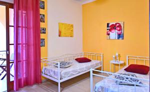 two beds in a room with yellow walls at Villa Efterpi in Kontokali