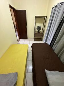 Habitación pequeña con 2 camas y espejo. en Apart 2 quartos Ribeiro, en Belo Horizonte